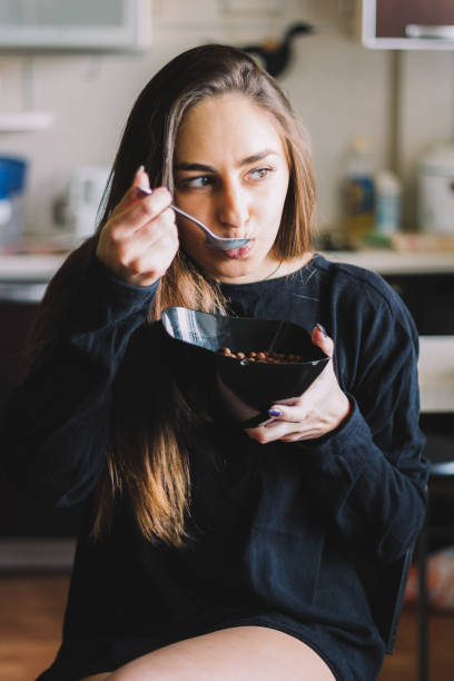istock beautiful young brunette girl  eating  cereal 913756922