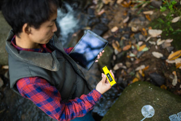 A scientist or researcher testing water quality with a pH meter
