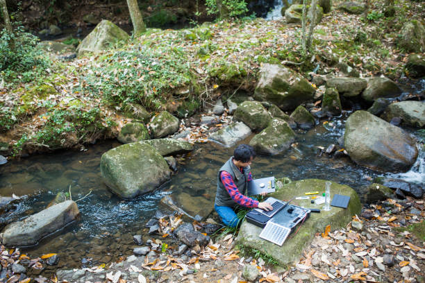 A scientist monitoring water quality from a solar powered field laboratory