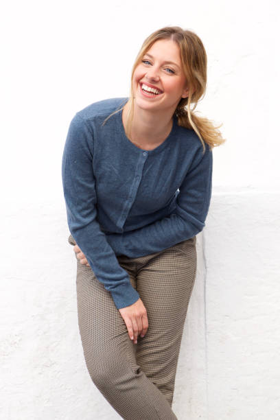 istock attractive young woman laughing against white wall 913777654