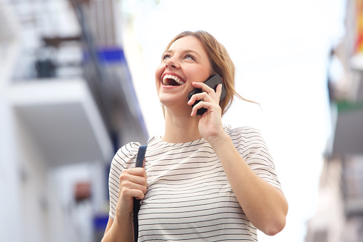 Portrait of attractive young woman laughing and talking on mobile phone