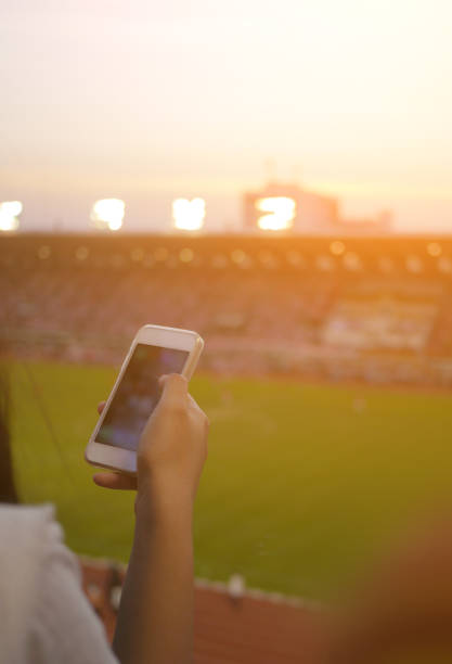 istock Women are using smart phone on the soccer stadium. 913783986