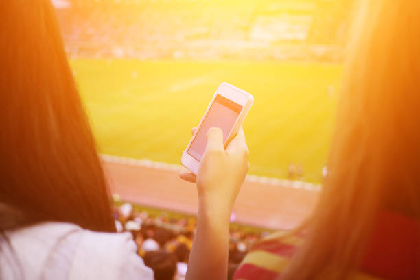 istock Women are using smart phone on the soccer stadium. 913784124