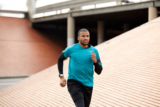 istock Athlete jogging on roadside by wall 913784404