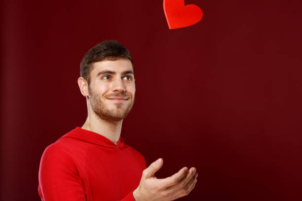 istock Young handsome man with a red heart in his hands on Valentine day 913786442
