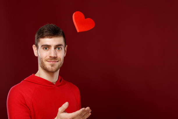 istock Young handsome man with a red heart in his hands on Valentine day 913786488