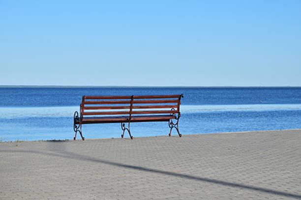 istock Seat bench on paved bank of river 913786766