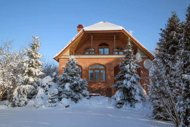 istock Snow-covered garden and brick house 913789348