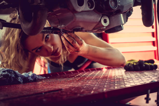 Blond woman repairing motorcycle. stock photo