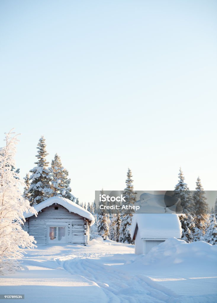 Wooden hut in a snowy sunny landscape Winter landscape with an wooden hut. Sunny bright day in Swedish Lapland. Swedish Lapland Stock Photo