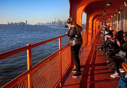 New York, USA-June 8, 2017: Many tourists take the ferry from New York to New Jersey to take pictures The statue of Liberty and the skyline of downtown of Manhattan