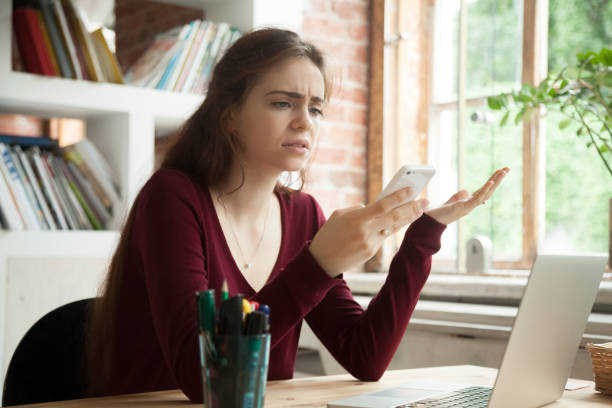 donna frustrata infastita che ha problemi a non lavorare sul cellulare - spam foto e immagini stock