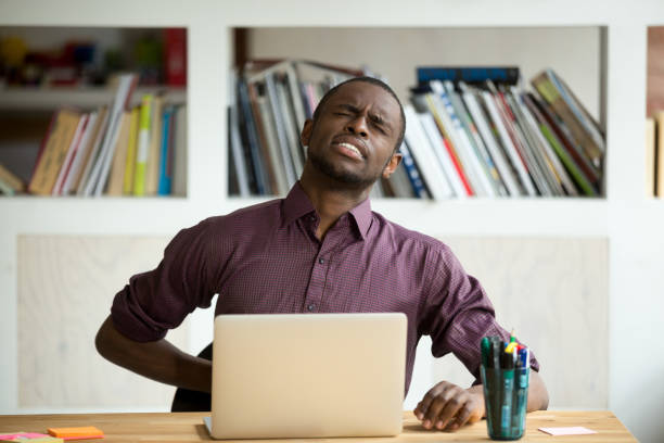 istock African-american man touching back sitting at desk feeling sudden backache 913812222