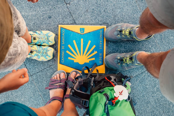Three pairs piligrims feet on the start of the Camino de Santiago or "The Way of Saint James " Bilbao, Spain - July 11, 2017:  Three pairs piligrims feet on the start of the Camino de Santiago or "The Way of Saint James " famous rout in Bilbao, Spain camino de santiago photos stock pictures, royalty-free photos & images