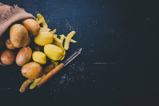 istock Raw potatoes on a black wooden background. Cooking. Free space for text. Top view. 913819018