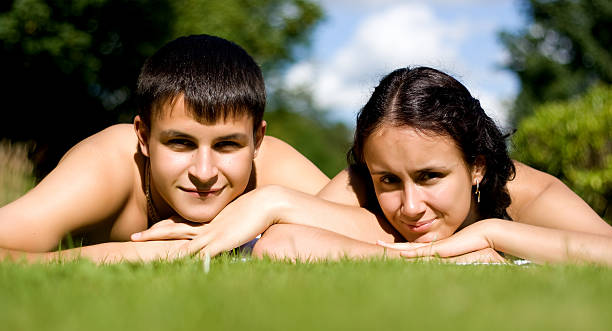 Happy couple lying on grass. stock photo