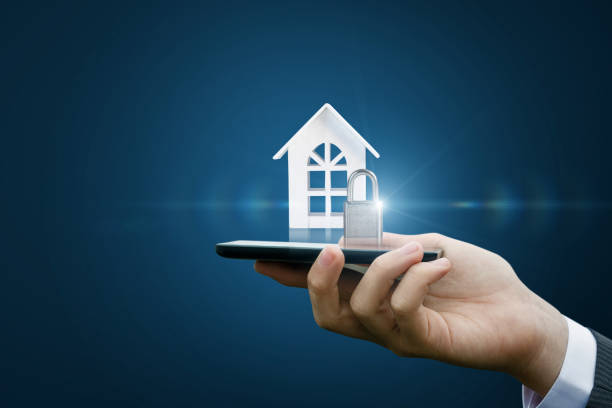 istock Hand with the mobile computer shows the house with a lock. 913827726