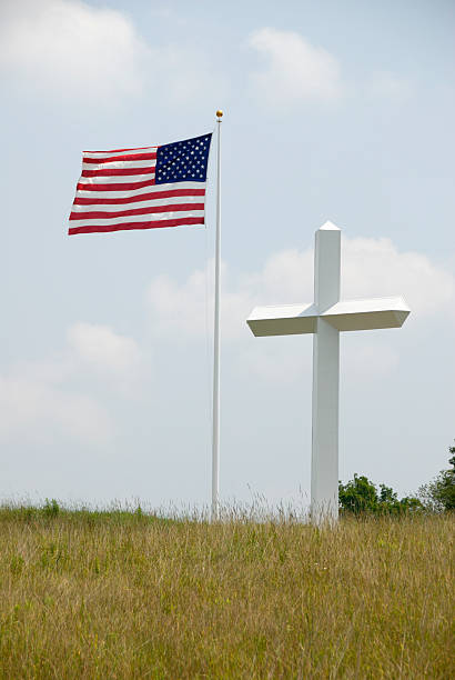 istock American Flag Flying Alongside A Large White Cross In Field 91383529
