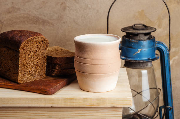 istock Clay pot with milk, rye bread and kerosene lantern 913835522