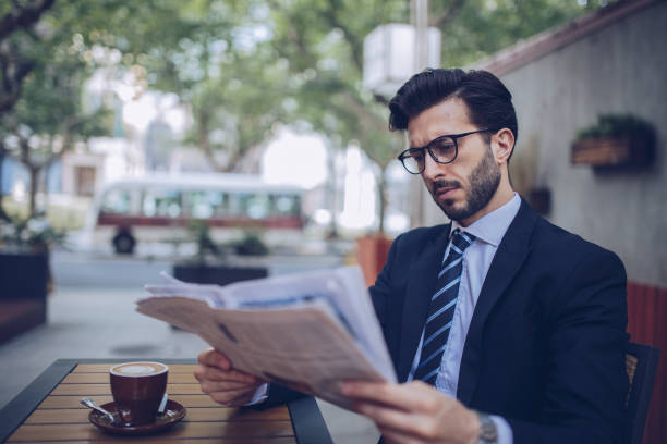 istock Gentleman reading news in cafe 913835648