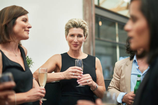 istock Elegant mature woman having a drink with colleagues after work 913840238