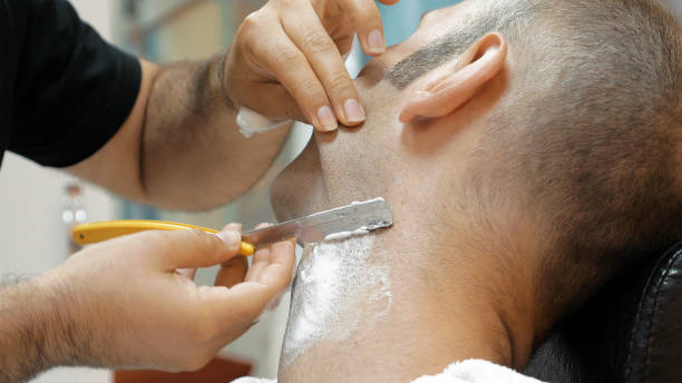 istock Barber is shaving his client in old fashion manner 913843716