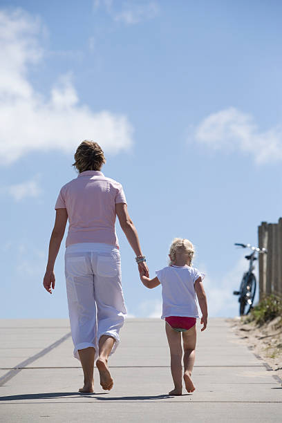 madre e hija caminando en la playa - beach family boardwalk footpath fotografías e imágenes de stock