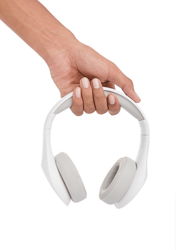 Hand holding white headphones on white background.