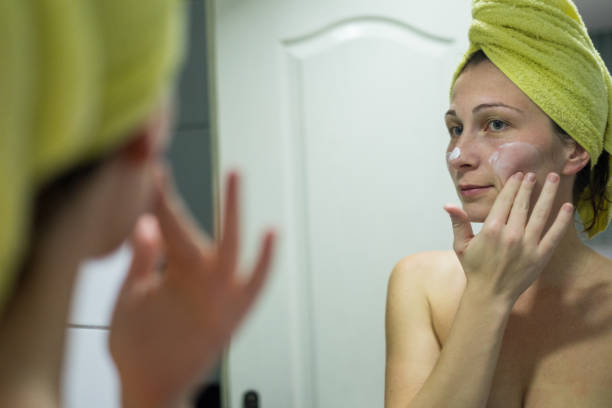 istock Young women applying face cream in front of mirror 913858122