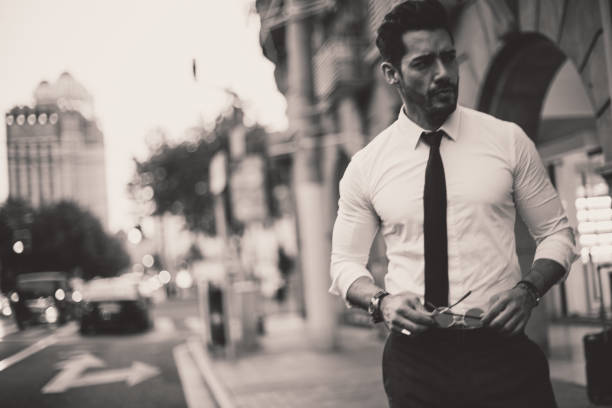 Handsome modern man standing on the street in big city, black and white.