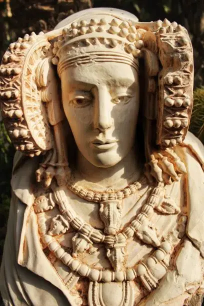 Photo of Lady of Elche bust in a garden under the sun