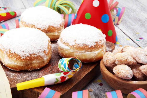 istock German donuts with jam and icing sugar. Carnival powdered sugar raised donuts with paper streamers. 913865216