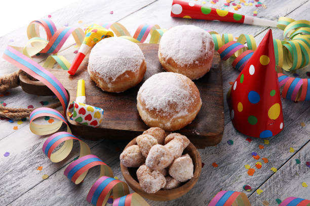istock German donuts with jam and icing sugar. Carnival powdered sugar raised donuts with paper streamers. 913865286
