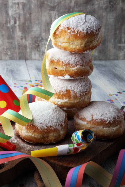 istock German donuts with jam and icing sugar. Carnival powdered sugar raised donuts with paper streamers. 913865384
