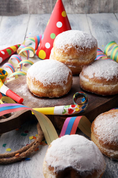 istock German donuts with jam and icing sugar. Carnival powdered sugar raised donuts with paper streamers. 913865498