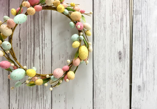 istock Easter egg wreath in pastel colors with wooden background and copy space 913868610