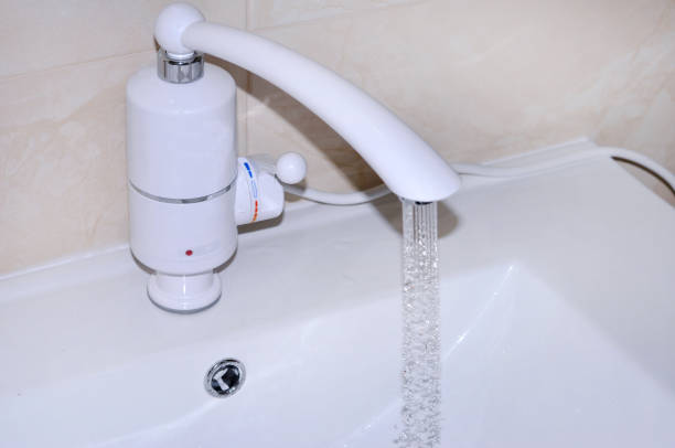 istock Modern chrome-plated tap fitted with plastic with built-in electric water heater. When the handle is raised, the hot water comes out. When the handle is lowered, cold water comes out 913870086