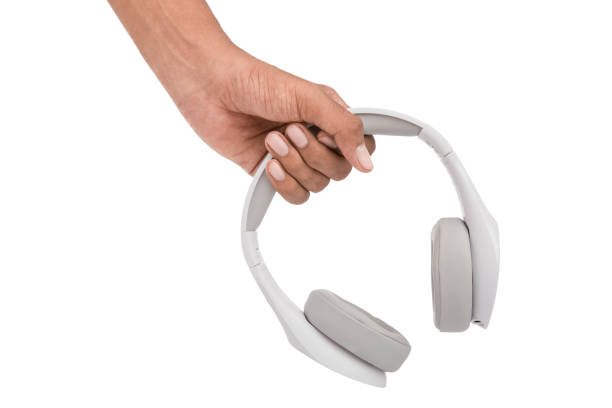 istock Hand holding white headphones 913873418