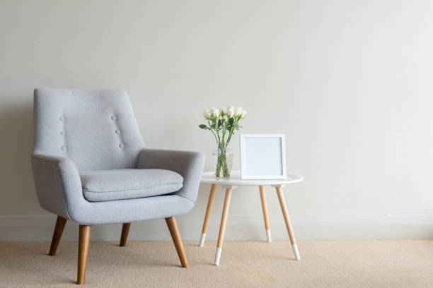 istock Retro armchair with roses and blank frame on table against wall 913882658