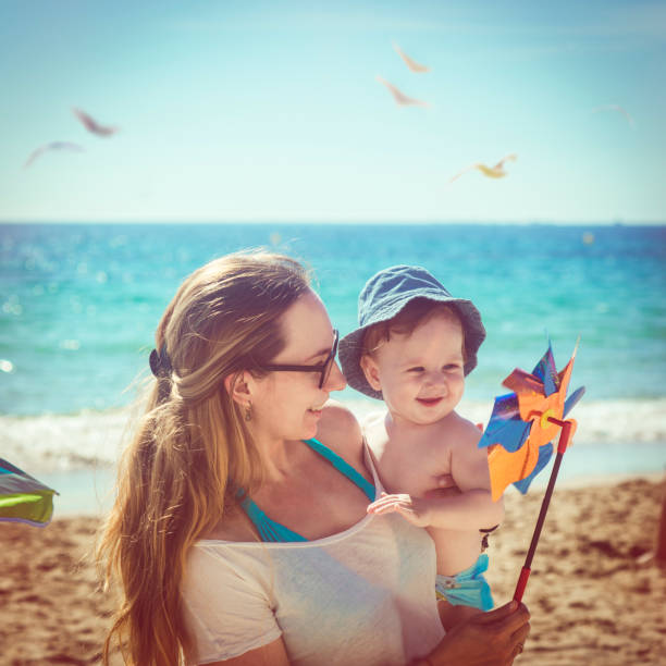 Mother and son playing with pinwheel on the beach