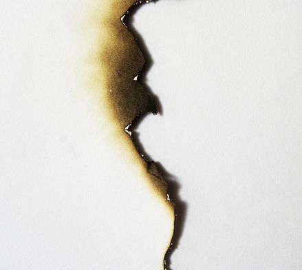 Uneven burned edge of a piece of paper