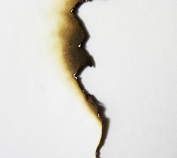 uneven burned edge of a piece of paper - yangın fotoğraflar stok fotoğraflar ve resimler