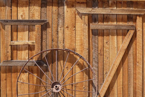 An old wagon wheel against the wall of a barn in Utah