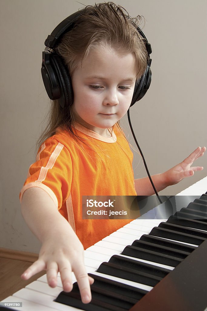 Girl at piano Nice girl learn playing piano Headphones Stock Photo