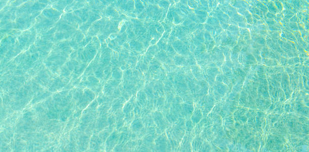 istock Swimming pool blue water with a wave and sunlight reflection 913922098