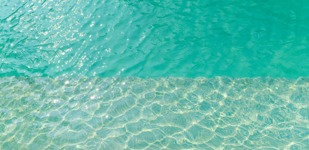 istock Swimming pool blue water with a wave and sunlight reflection 913922294