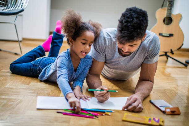 istock Father and daughter coloring together 913931226
