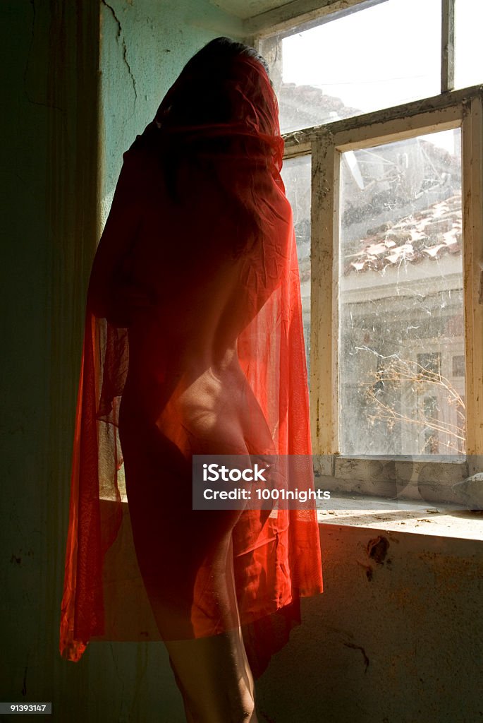 Mulher com véu vermelhos na frente de uma antiga janela - Foto de stock de Nu royalty-free