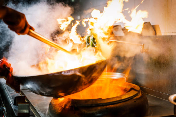 istock Chef in restaurant kitchen at stove with high burning flames 913931808