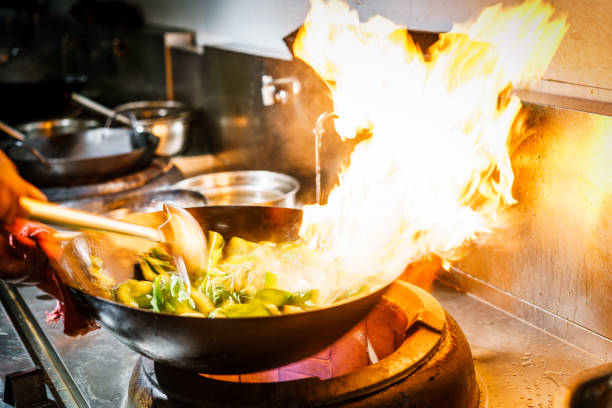 istock Chef in restaurant kitchen at stove with high burning flames 913931814